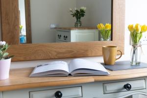 um livro aberto em um balcão com uma xícara de café em NEW Romantic, dog friendly hideaway, Snowdon views em Caernarfon