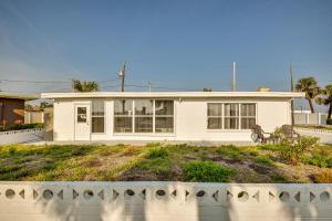a white house with a bench in front of it at Ormond Beach Home: Walk to Community Beach! in Ormond Beach