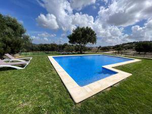 a swimming pool in the middle of a grass field at Finca Florida in Benalup Casas Viejas