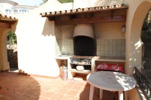 kuchnia na świeżym powietrzu z kuchenką i stołem w obiekcie Kanky 6 - modern, well-equipped villa with private pool in Benissa coast w mieście Benissa