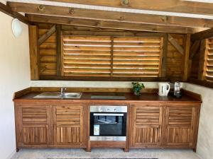 a kitchen with a sink and a microwave at Appartement Bois Banane in Lamentin