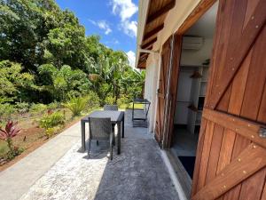 a table and chairs on the porch of a house at Appartement Bois Banane in Lamentin