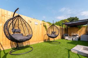 duas cadeiras de balanço sentadas na relva num quintal em Exquisite Cardiff Apartments- with Garden Lounge & Games Room em Cardiff