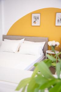 1 dormitorio con 1 cama con pared amarilla en Lulu Suites - Sunflower, en Golem