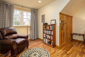 a living room with a leather chair and a book shelf at Mockingbird Mountain Spa and Retreat in Luray