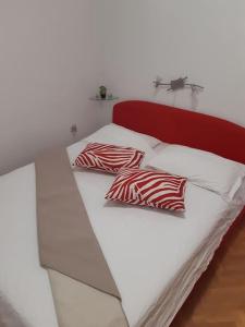 スタリー・グラードにあるApartman Antonelaのベッド(赤と白の枕2つ付)