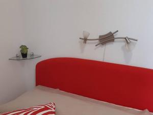 スタリー・グラードにあるApartman Antonelaの赤いヘッドボードと白い壁のベッドルーム1室