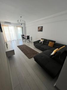 a living room with a black couch and a table at The Bliss in Râmnicu Vâlcea