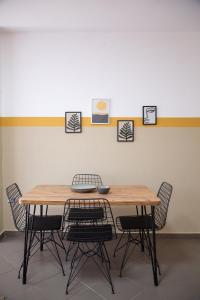 una mesa de comedor con 4 sillas alrededor en Lulu Suites - Sunflower, en Golem