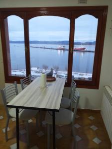 a dining room table and chairs with a view of the water at Mirando al Sur in Ushuaia