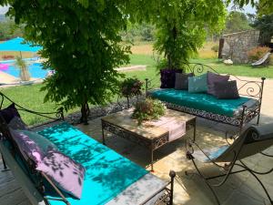 een patio met banken en tafels en een zwembad bij Mas provençal les vanades in Aups