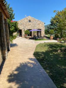 een stenen huis met een tafel en een patio bij Mas provençal les vanades in Aups