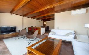 uma sala de estar com um sofá branco e uma televisão em Luxury Rocamar Primera línea de marTerraza em Tossa de Mar
