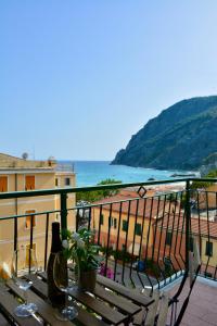 a table on a balcony with a view of the ocean at Monterosso Rooms in Monterosso al Mare