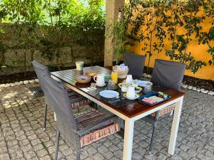 uma mesa de madeira com cadeiras e comida em BERGUI Guesthouse - Guimarães em Guimarães
