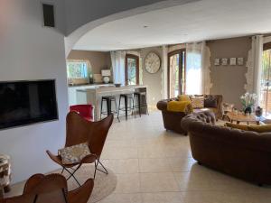 een woonkamer met banken en stoelen en een keuken bij Mas provençal les vanades in Aups