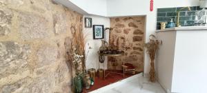 una camera con una parete in pietra, un tavolo e bottiglie di Escapade de charme au 18'55 - Bourg de Duravel a Duravel