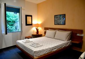 a bedroom with a bed with white sheets and a window at Monterosso Rooms in Monterosso al Mare