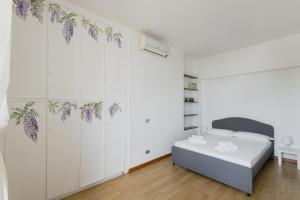 a bedroom with a bed with purple flowers on the wall at Easylife - Elegante attico 2 min da Parco Sempione in Milan