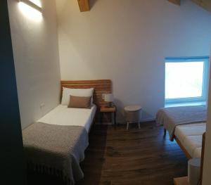 Cette petite chambre comprend 2 lits et une fenêtre. dans l'établissement Casa Carmen, à Molina di Ledro