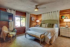 Schlafzimmer mit einem Bett, einem TV und einem Stuhl in der Unterkunft Cabin in Lake Lure Near Chimney Rock and Asheville! in Lake Lure
