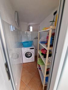 a small bathroom with a washing machine and a washer at Casa Dei Nonni in Ischia