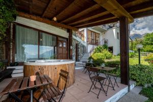 - un bain à remous sur une terrasse avec une table et des chaises dans l'établissement Agribenessere Brenzio, à Consiglio di Rumo