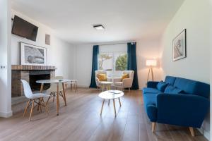 sala de estar con sofá azul y sillas en Hotel Playa Las Sinas en Villanueva de Arosa