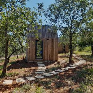 une petite maison en bois dans un champ arboré dans l'établissement Refugio do Carrascal, à Tomar