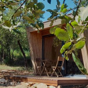 une cabane en bois avec une chaise en face de celle-ci dans l'établissement Refugio do Carrascal, à Tomar