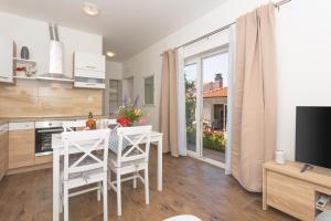 a kitchen and dining room with a table and chairs at Mara in Šibenik +18 photos