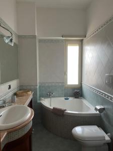 リド・ディ・オスティアにあるAttico con terrazza in Via dei Traghettiの浴槽、トイレ、洗面台を備えたバスルーム +21枚の写真