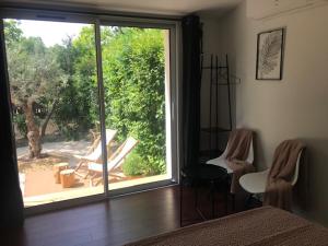 a bedroom with a sliding glass door to a patio at La Maison 1440 in L'Isle-sur-la-Sorgue