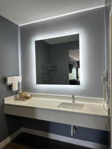 uma casa de banho com um lavatório e um espelho em Atlantis Inn Suites em Houston