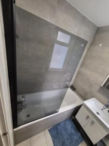 La salle de bains est pourvue d'une baignoire et d'un lavabo. dans l'établissement Beautiful 2-bed flat in the heart of Hendon, à The Hyde