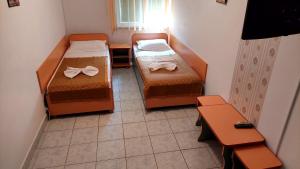 Habitación pequeña con 2 camas y mesa. en Hostel Atlantic 1 Neptun, en Neptun