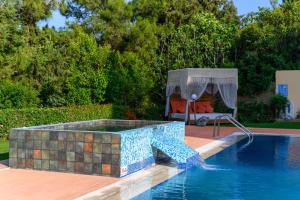 a swimming pool with a table and a chair next to it at Kallithea Breeze Luxury Villa in Koskinou