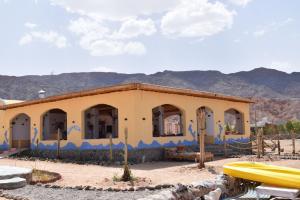 un edificio amarillo con pintura azul. en Abo Hamada Azure Camp en Nuweiba