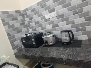 a kitchen counter with a toaster and a slow cooker at Hostel KLIA in Sepang