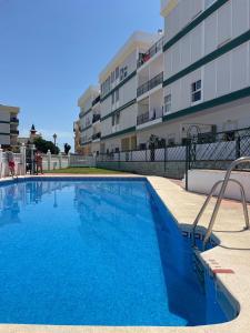 a large swimming pool in front of a building at Piso con parking y piscina en Torrox costa in Torrox Costa