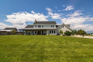 a white house with a large yard at Three Bears Get Away farmhouse in Hamilton