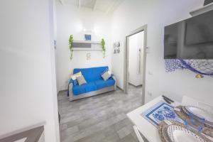 a living room with a blue couch and a tv at Sun&Garden Flat in Cagliari