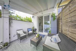 a patio with chairs and a couch and a table at Sun&Garden Flat in Cagliari