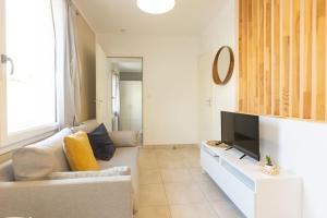 a living room with a couch and a tv at T2 plain-pied à 3 minutes du centre in Castres