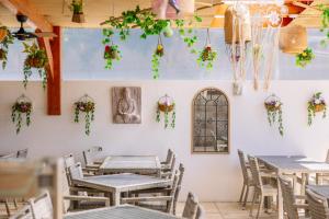 a restaurant with tables and chairs and plants on the wall at Grand Muthu Forte Da Oura in Albufeira