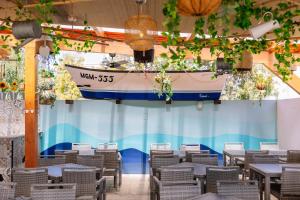 a boat hanging from the ceiling of a room with tables and chairs at Grand Muthu Forte Da Oura in Albufeira