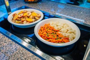 two bowls of vegetables and rice on a counter at Grand Muthu Forte Da Oura in Albufeira