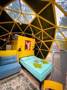 a room in a dome with a bed and a couch at Čiki Puki Glamping in Palanga
