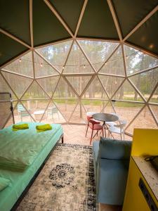 Cette chambre comprend un lit et une table dans un igloo. dans l'établissement Čiki Puki Glamping, à Palanga