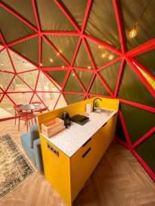 a room with a yellow and red geometric wall at Čiki Puki Glamping in Palanga